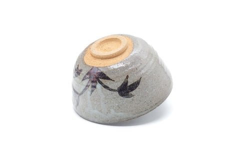 Underside of the chawan showing the pale foot and painted motif on the body.