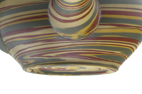 Close-up of the marbled nerikomi stripes in yellow, green, red and brown.