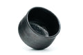 Black ceramic cup on a white background - tilted