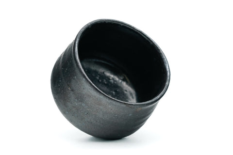 Black ceramic cup on a white background - tilted