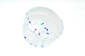 Clear glass matcha bowl with blue specks on a white background