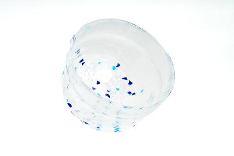 Clear glass matcha bowl with blue specks on a white background