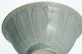 Celadon bowl with lotus petal design on a white background