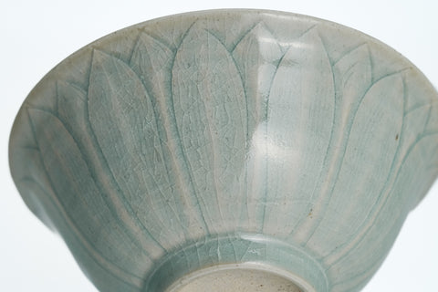 Celadon bowl with lotus petal design on a white background