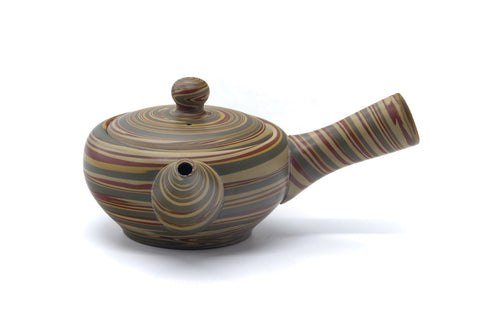 Side view of the nerikomi kyusu with the handle to the right and spout to the left.