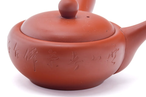 Overhead angled view showing the lid and engraved calligraphy on the body