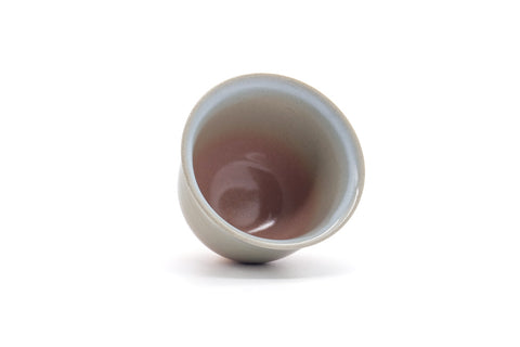 Tilted view showing the pink-glazed interior of the cup.