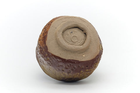 Underside of the yunomi showing the spiral-trimmed foot ring on bare clay.
