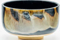 Side view of the dark hantsutsu chawan showing the drip glaze over the body