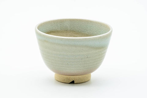 Single beige-white Hagi yunomi teacup, front view, soft crackle-glazed surface.