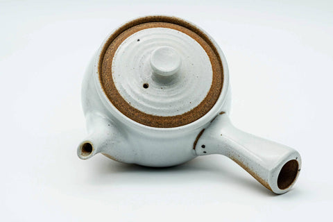 Overhead view of the white kyusu, lid on, showing the handle and spout.