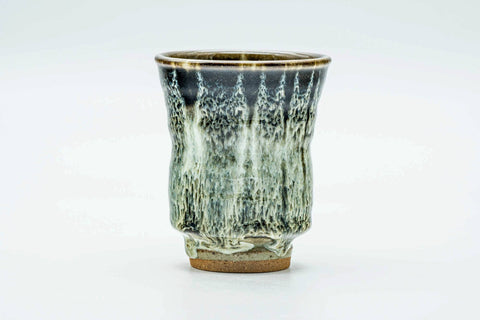 Slightly angled view of the tall drip-glazed yunomi showing the streaked glaze running down the body.