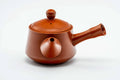 Three-quarter view of the red shudei kyusu with the lid on.