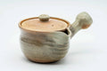 Beige weathered Hagi-yaki side-handle kyusu teapot, three-quarter view with lid on and vertical brushed glaze