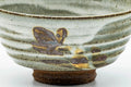 Close-up of the exterior highlighting the painted floral motif over the grey-white drip glaze.