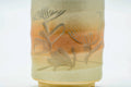 Close-up of a cup, showing the engraved floral decoration over the spiraling glaze.