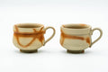 The two handled teacups side by side without saucers, front view, showing the C-shaped handles.