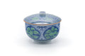 Arita-yaki lidded yunomi with lid on, front view, painted with blue and green leaves.