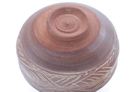 Close-up of the inverted hakeme chawan base, showing the spiral-trimmed foot and carved lower band