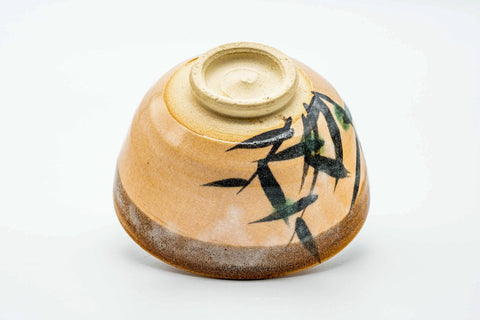 Underside of the bowl showing the unglazed foot and base, with grass brushwork on the body.