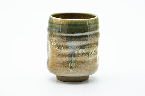 The yunomi from another angle, showing the spiral ridges and drip glaze.