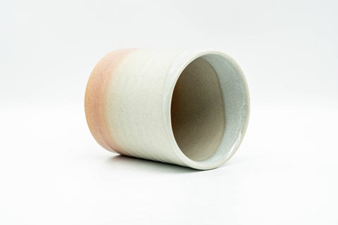 Beige, peach and white glazed Hagi-yaki yunomi teacup - tilted view showing the glazed interior and rim