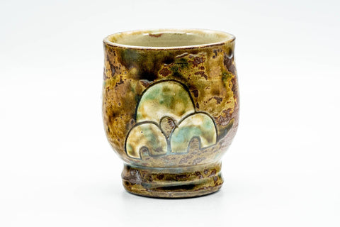 Three-quarter view showing the engraved fish and the bubbled iridescent glaze surface.