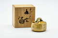 Basket-shaped Seto-yaki kogo incense container displayed beside its calligraphy-marked wooden presentation box.