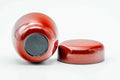 The red caddy tipped onto its side next to the separate lid, exposing the dark base.