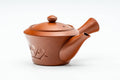 Three-quarter view of the red clay teapot, lid on, side handle to the right, with a floral band engraved on the body.