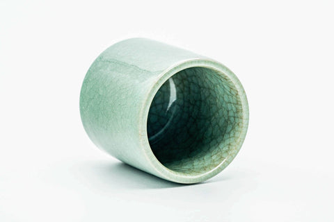 Teacup tilted to show the glazed interior and crazed rim.