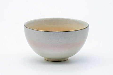 The cup from the reverse, showing a gold rim band over the pale glaze.