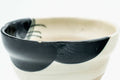 Profile view showing the bold black brushwork sweeping across the cup.