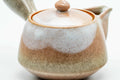 Three-quarter closeup of the lid seated on the beige-pink Hagi-yaki kyusu body