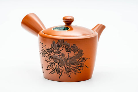 Teapot alone, front view, showing the spout, lid, side handle, and engraved floral relief.