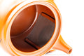 Overhead view looking into the open teapot, showing the interior and built-in ceramic mesh strainer.