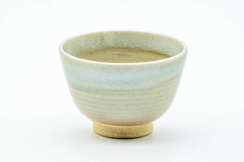 Front view of a Hagi teacup showing the muted cream-beige glaze and tapered form.
