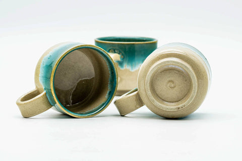 One cup tipped on its side, showing the side handle and foot.