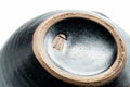 Close-up of the lid and side handle showing the matte black and brown drip-glaze finish.