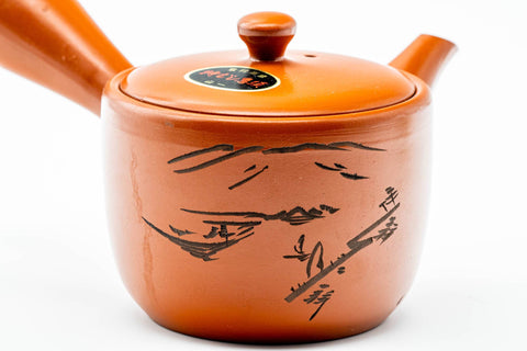 Three-quarter view highlighting the engraved scenery along the side of the teapot.