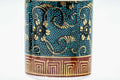 Close-up of a cup's body, showing the blue glaze with gold florals and raised aochibu dots.