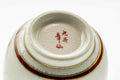 Underside of the cup showing the foot and a red maker's mark.