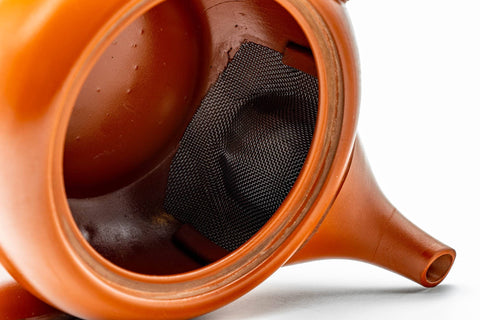 Teapot with lid removed, looking inside to show the ceramic mesh strainer.