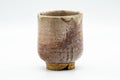 Three-quarter view of the Hagi-yaki yunomi showing tonal variation across the cream and rust glaze