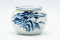 Front view of the cha-koboshi bowl painted with a blue mountainous landscape on white porcelain.