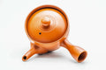 Overhead view of the red kyusu, lid on, showing the handle and spout.
