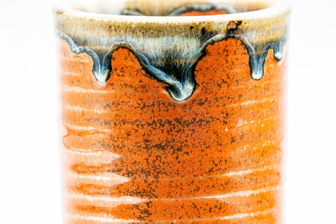 Wider view highlighting the blue-green drip glaze running down from the rim over the red body.