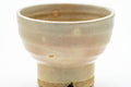 Front view emphasizing the tall foot and the gohonte-spotted beige glaze.