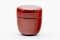 Three-quarter view of the closed red lacquer caddy.