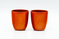 The two matching red shudei yunomi teacups shown upright side by side.